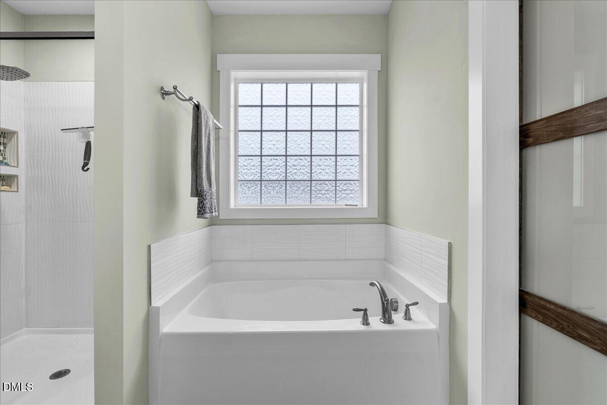 47 Kiowa Court Willow Spring, NC 27592 - Photo 16 of 30 a white bath tub sitting next to a window
