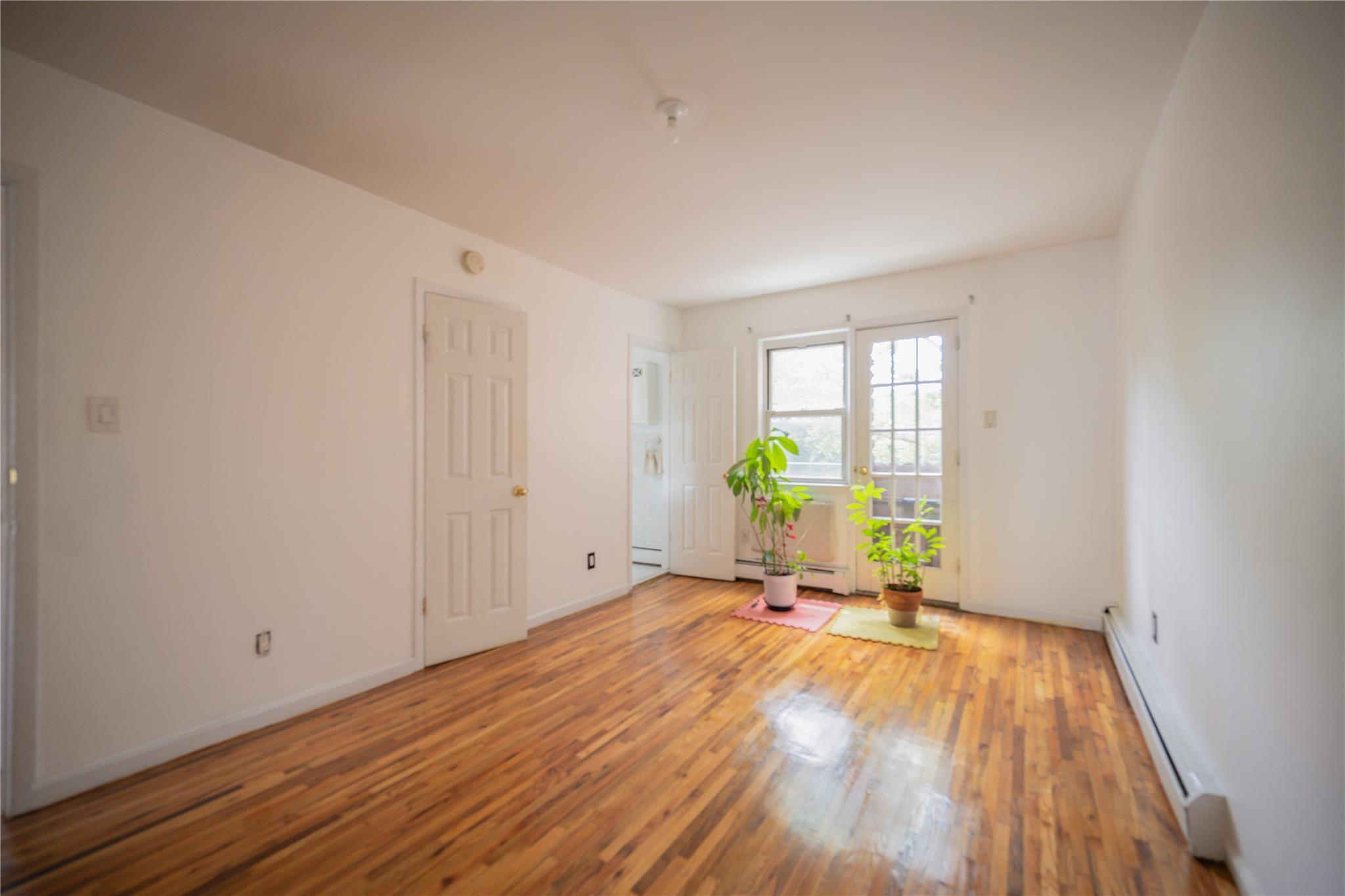 59-38 Xenia Street Queens, NY 11368 - Photo 12 of 16 a view of a room with a window and wooden floor