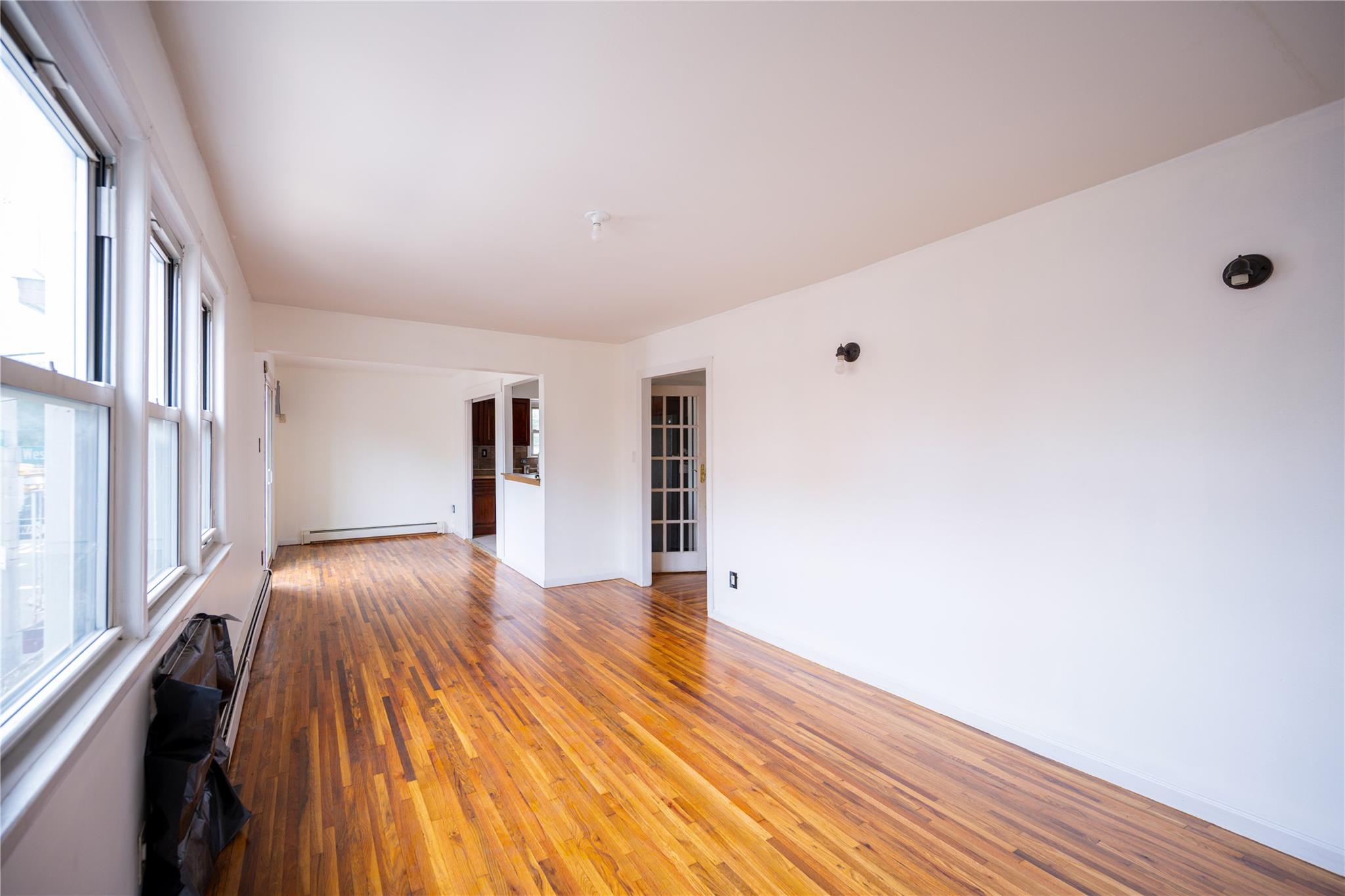 59-38 Xenia Street Queens, NY 11368 - Photo 6 of 16 a view of empty room with wooden floor and fan