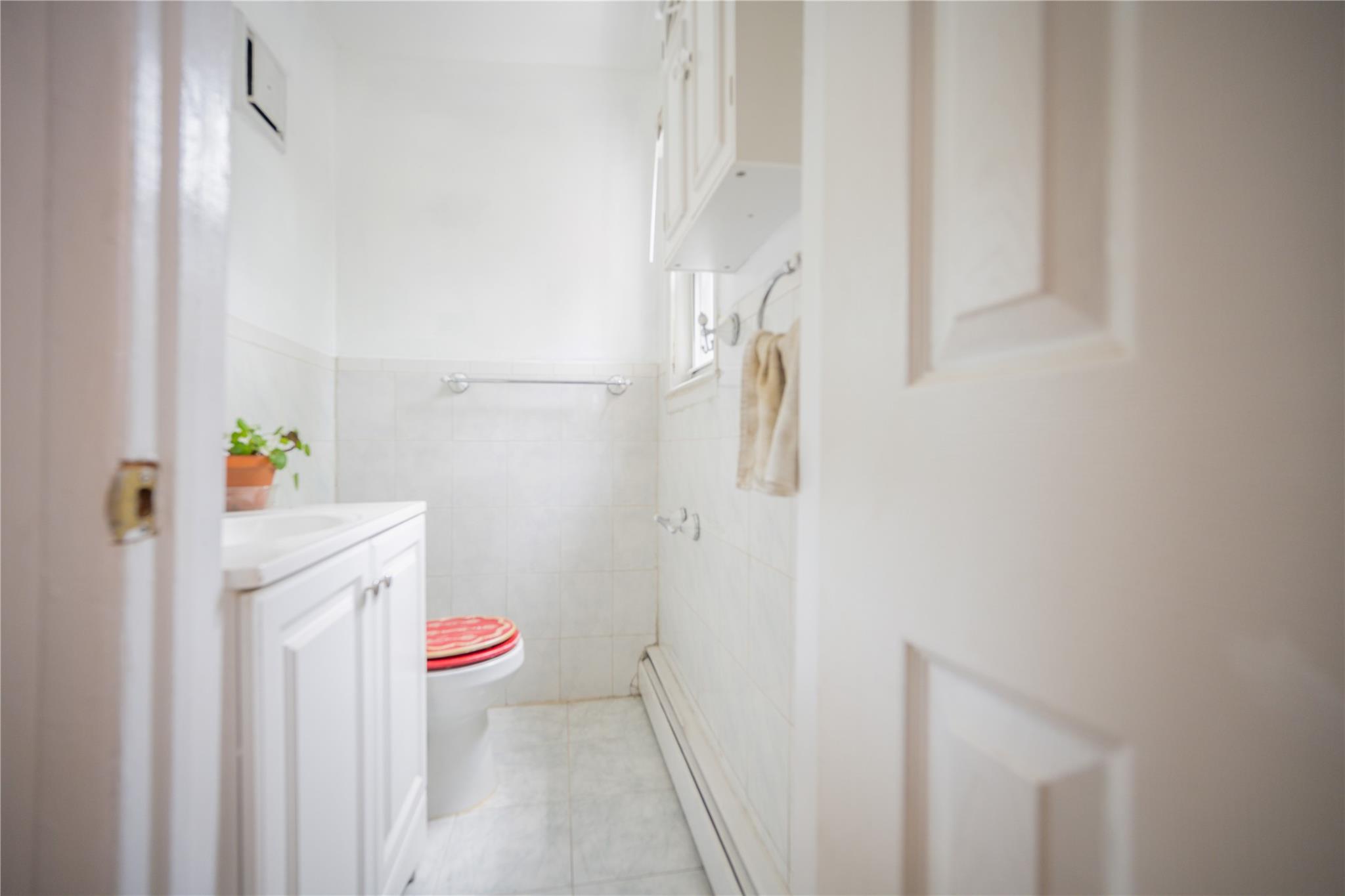 59-38 Xenia Street Queens, NY 11368 - Photo 9 of 16 a bathroom with a sink a bath tub and a shower curtain