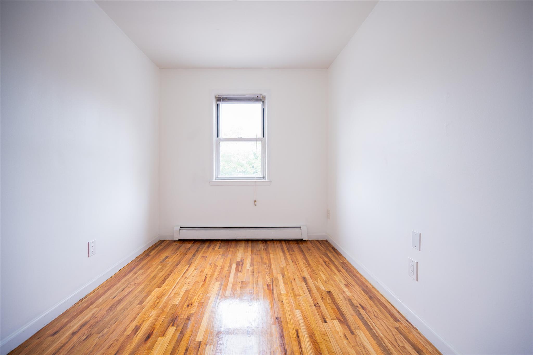 59-38 Xenia Street Queens, NY 11368 - Photo 10 of 16 a view of a room with wooden floor and window