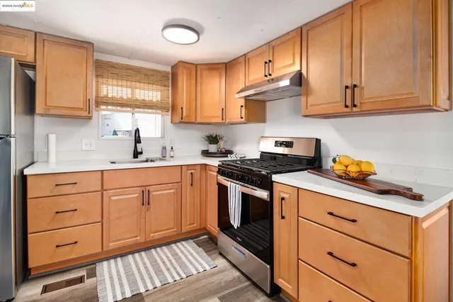 a kitchen with granite countertop white cabinets stainless steel appliances and sink