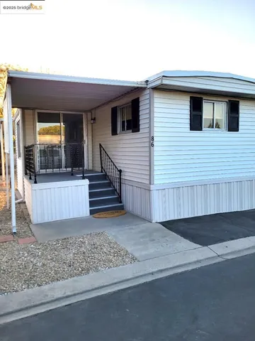 a view of a small house with wooden floor and fence