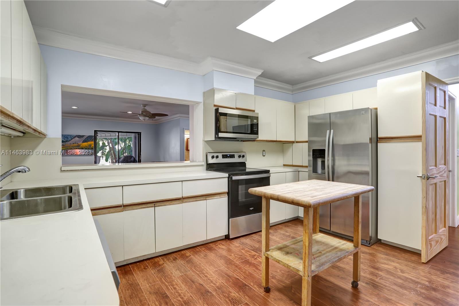 7700 Hawthorne Avenue Miami Beach, FL 33141 - Photo 15 of 36 a kitchen with stainless steel appliances a stove a sink dishwasher a refrigerator and a stove with wooden floor