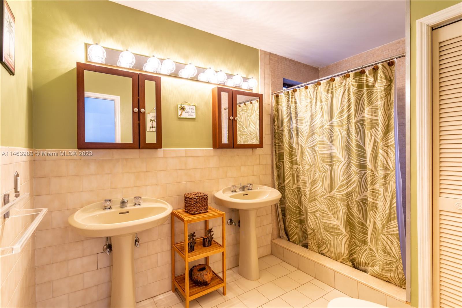 7700 Hawthorne Avenue Miami Beach, FL 33141 - Photo 35 of 36 a bathroom with a sink and a mirror
