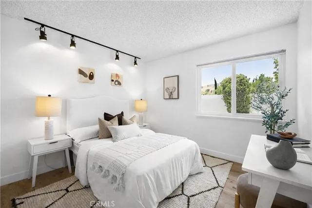 a bedroom with a bed window and table chair