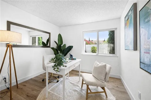 a view of a workspace with furniture and a window