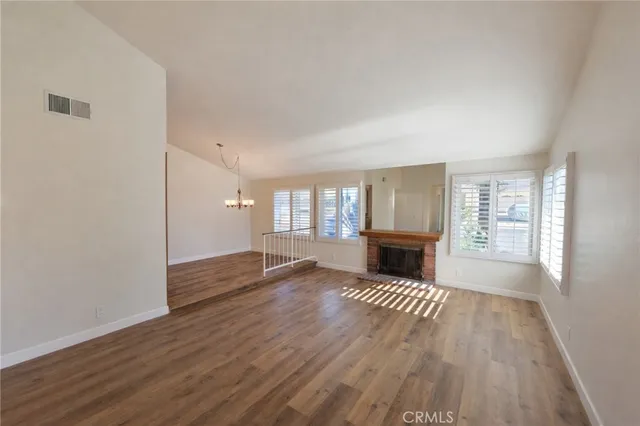 an empty room with wooden floor and fireplace