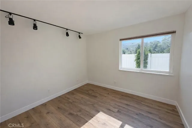 a view of a room with wooden floor and windows