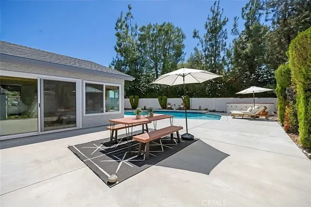 a view of a patio with a table and chairs under an umbrella