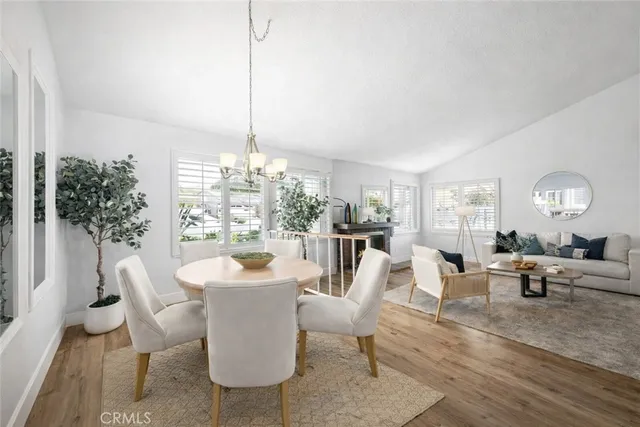 a living room with furniture a dining table and a large window