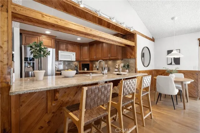 a kitchen with granite countertop a table chairs stove a sink and dishwasher