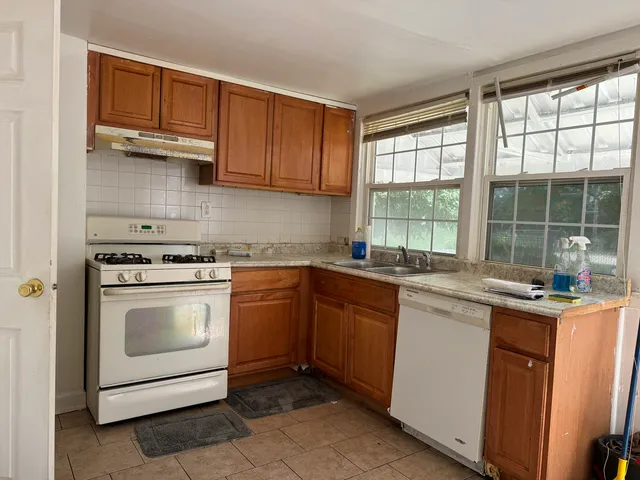 a kitchen with granite countertop a sink stainless steel appliances and cabinets