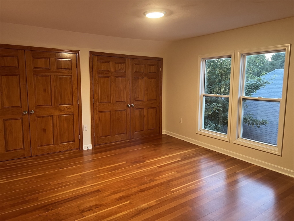 194 Auburn Street, Unit 2 Newton, MA 02466 - Photo 7 of 19 an empty room with wooden floor and windows