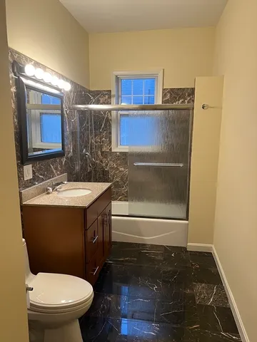 a bathroom with a toilet a sink and mirror