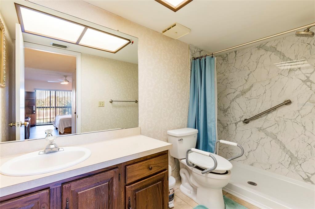 2593 Countryside Boulevard, Unit 7307 Clearwater, FL 33761 - Photo 23 of 32 a bathroom with a sink toilet vanity and shower