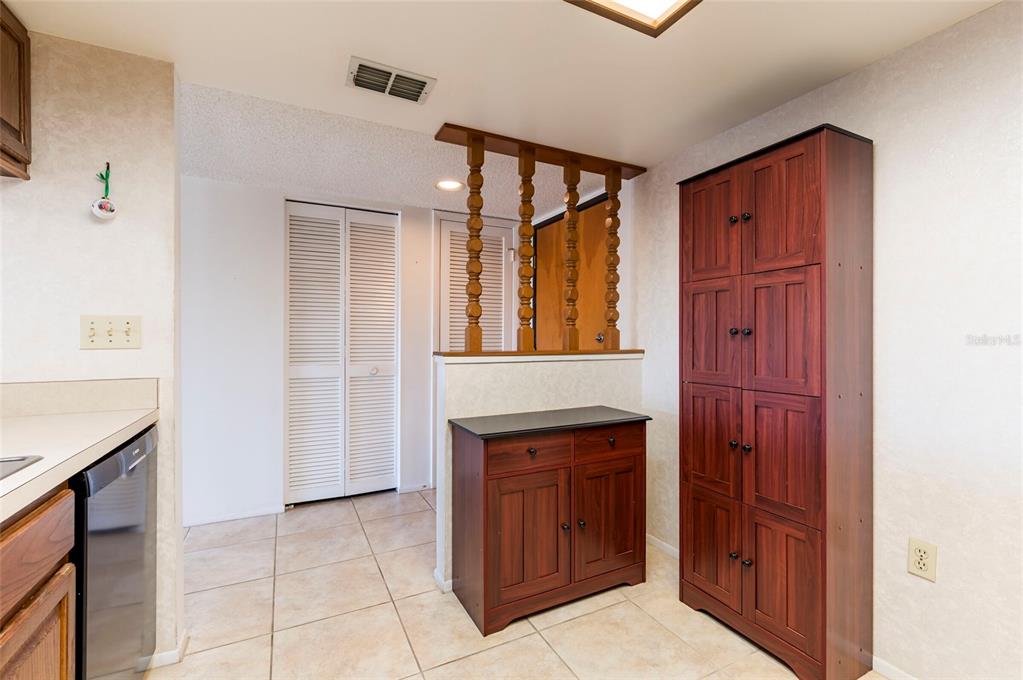 2593 Countryside Boulevard, Unit 7307 Clearwater, FL 33761 - Photo 7 of 32 a hallway with cabinets and wooden floor