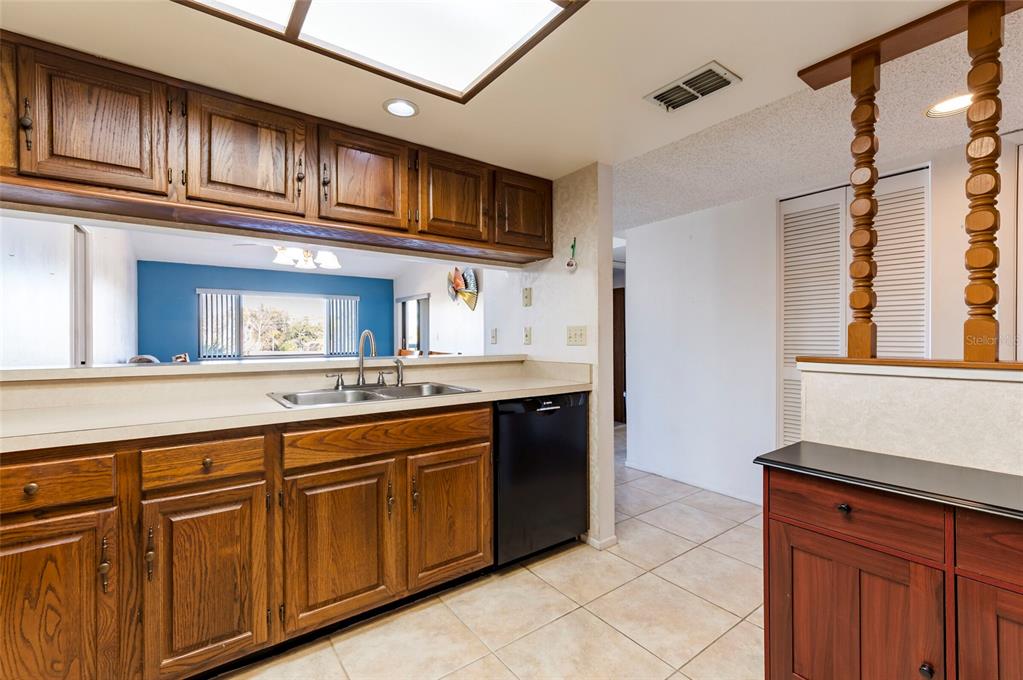 2593 Countryside Boulevard, Unit 7307 Clearwater, FL 33761 - Photo 8 of 32 a kitchen with stainless steel appliances granite countertop a sink and dishwasher a refrigerator with wooden cabinets