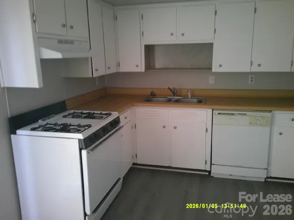 a kitchen with granite countertop white cabinets and white appliances