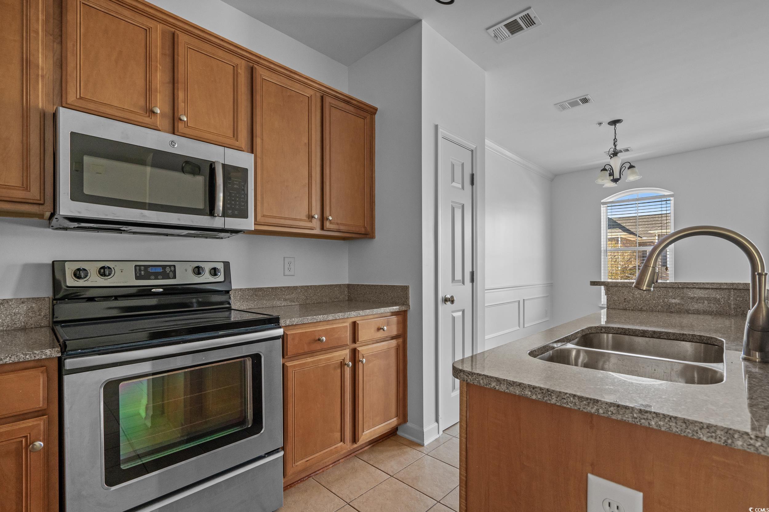 2798 Howard Avenue, Unit B Myrtle Beach, SC 29577 - Photo 14 of 40 Kitchen featuring stainless steel appliances, brown cabinets, hanging light fixtures, and dark stone counters