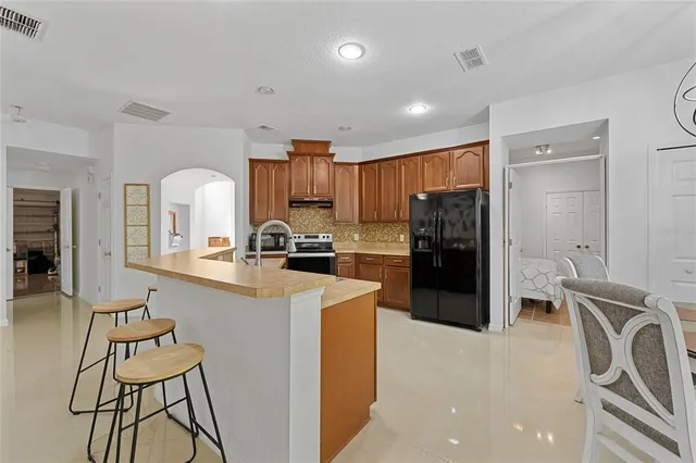 a kitchen with a refrigerator and a stove top oven with wooden floor