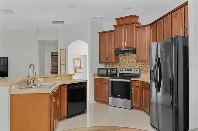 a kitchen with stainless steel appliances granite countertop a refrigerator sink and cabinets