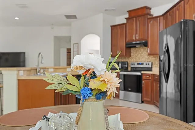 a kitchen with stainless steel appliances a sink a microwave a refrigerator and cabinets