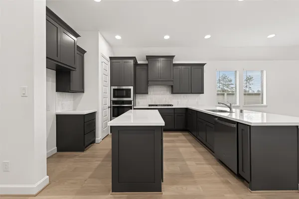 a kitchen with stainless steel appliances kitchen island granite countertop a sink counter space and cabinets