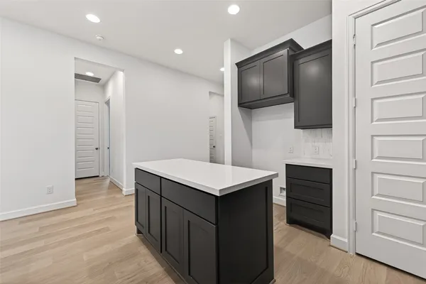 a kitchen that has a microwave a stove and a refrigerator with wooden floor