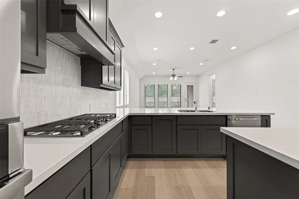 a kitchen with stainless steel appliances granite countertop a stove a sink and a microwave