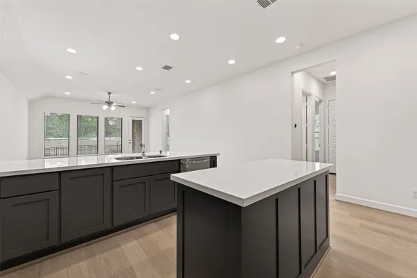 a kitchen with a sink cabinets and wooden floor