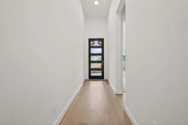 a view of a hallway with wooden floor and entryway