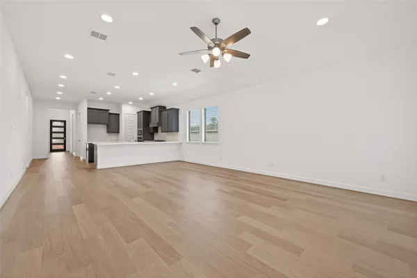 a view of an empty room with a kitchen