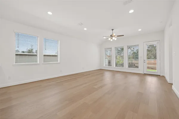 an empty room with wooden floor and windows