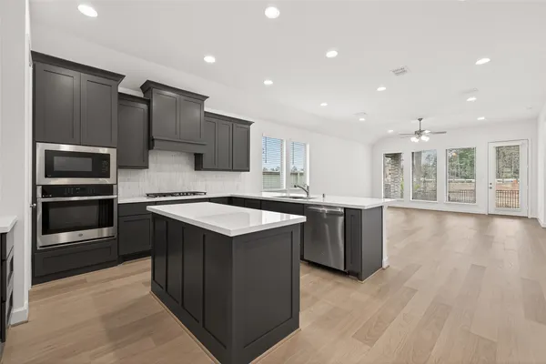 a kitchen with kitchen island granite countertop a stove and a sink