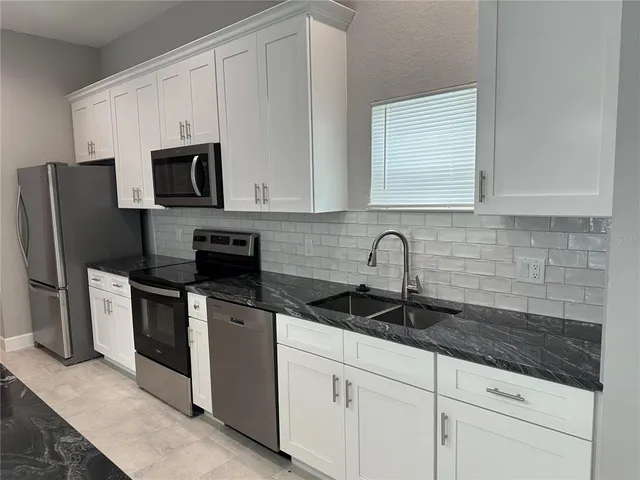 a bathroom with a granite countertop sink and cabinets