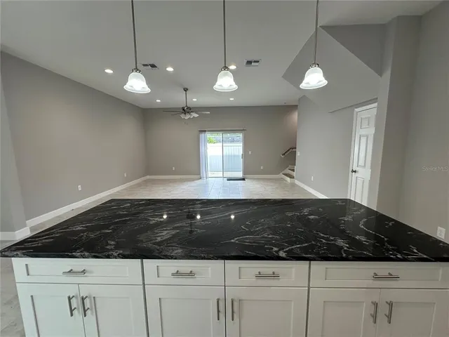 a bathroom with a granite countertop toilet sink and mirror