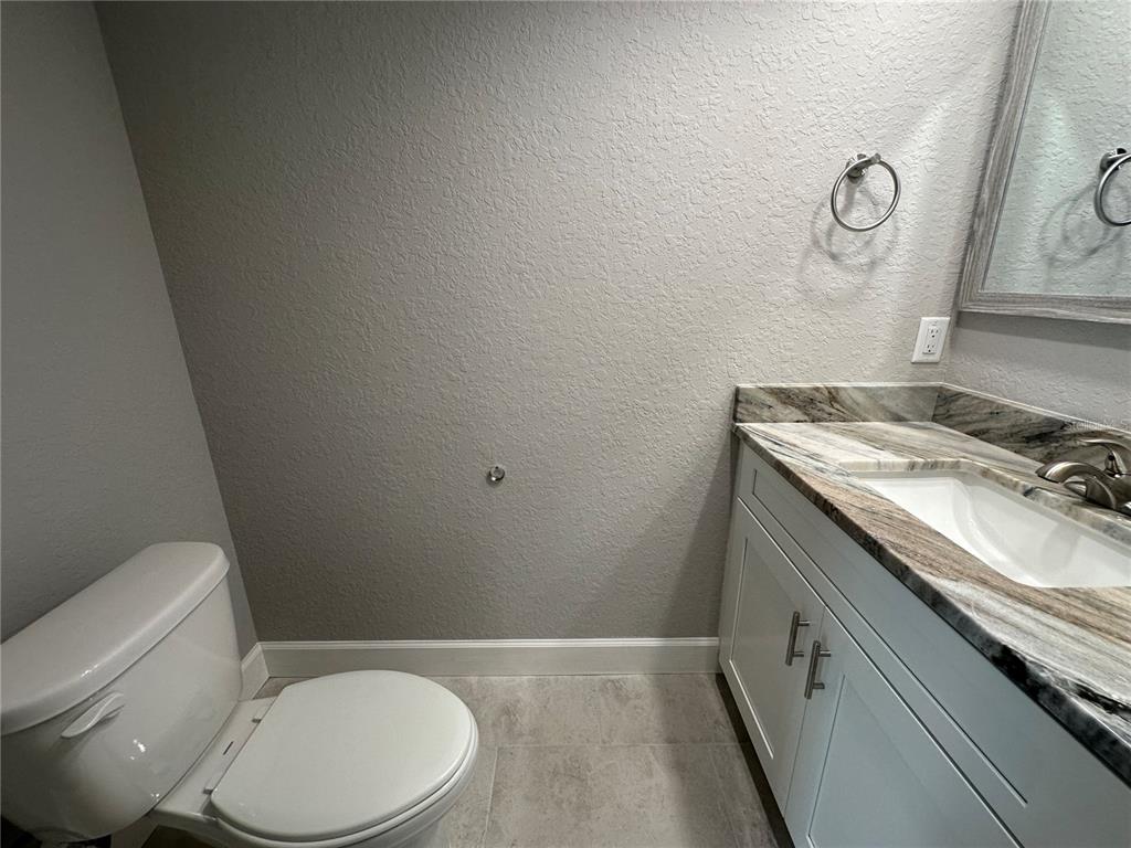 4920 8th Street Zephyrhills, FL 33542 - Photo 20 of 57 a bathroom with a granite countertop toilet sink and mirror