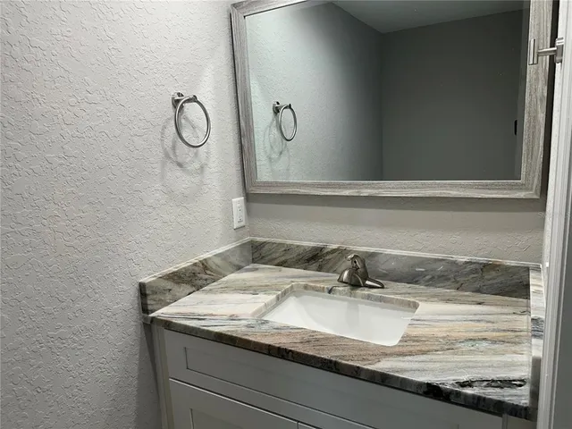 a kitchen with white cabinets and black appliances
