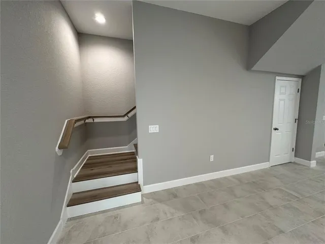 an empty room with wooden floor and a ceiling fan