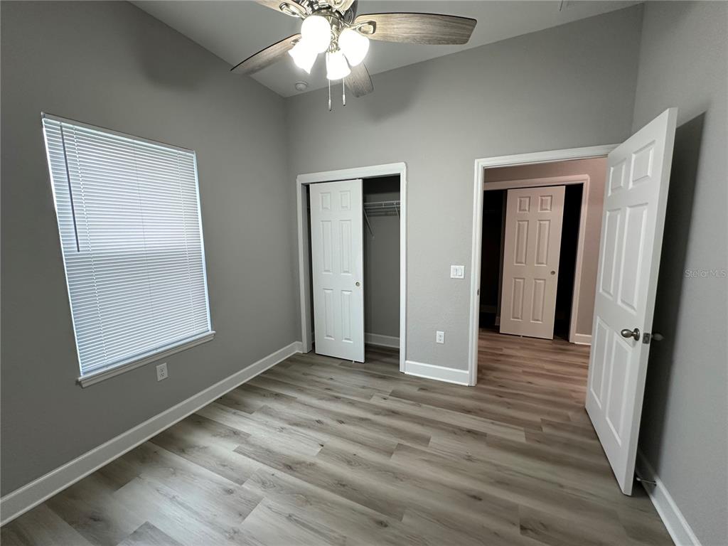 4920 8th Street Zephyrhills, FL 33542 - Photo 30 of 57 an empty room with wooden floor and a ceiling fan