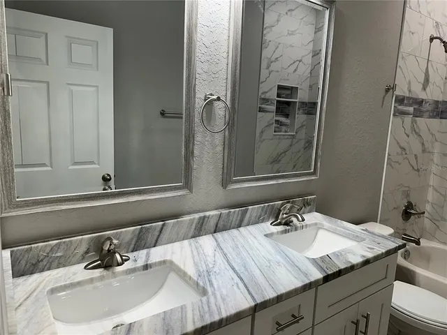 a view of a hallway with wooden floor and a chandelier