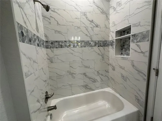 an empty room with wooden floor closet fan and windows