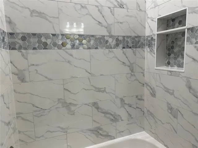 an empty room with wooden floor ceiling fan and window