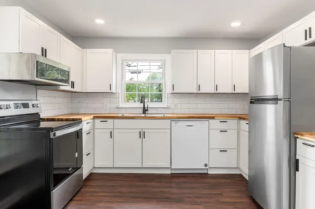 a kitchen with stainless steel appliances granite countertop a refrigerator and a stove top oven