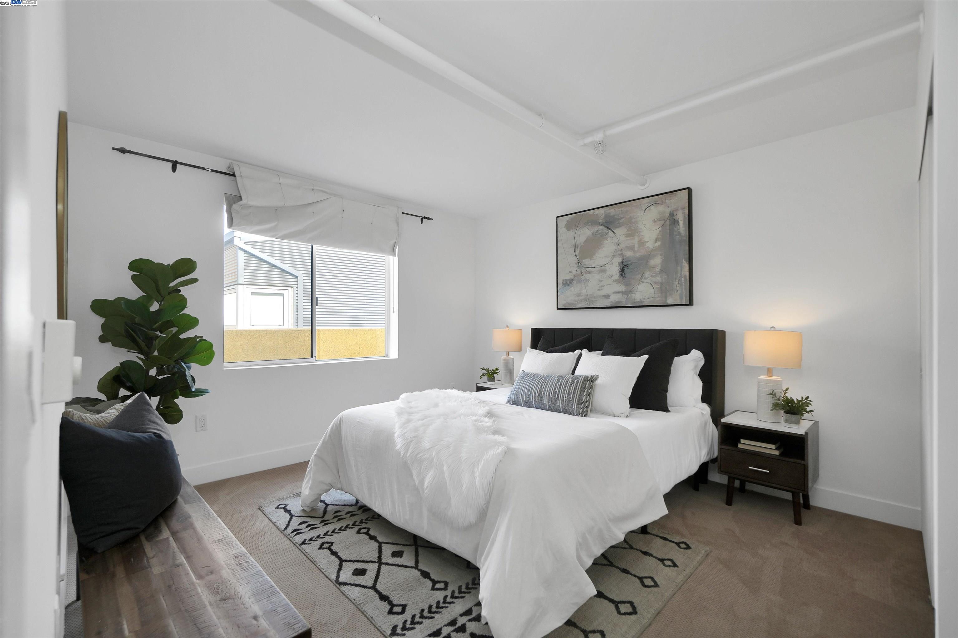 311 Oak Street, Unit PH25 Oakland, CA 94607 - Photo 4 of 14 a bedroom with a bed and a potted plant