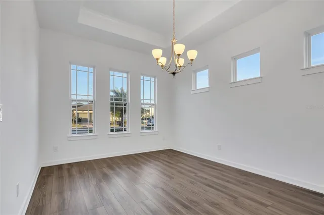 a view of a room with wooden floor and chandelier