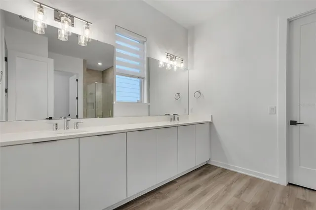 a bathroom with a double vanity sink and a mirror