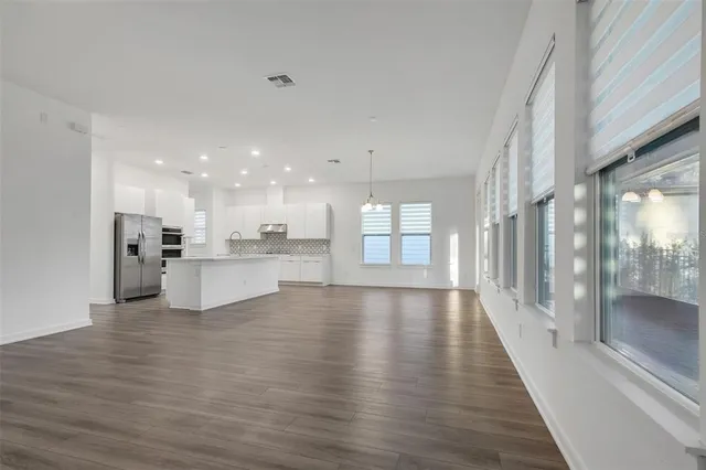 a view of an empty room and kitchen view