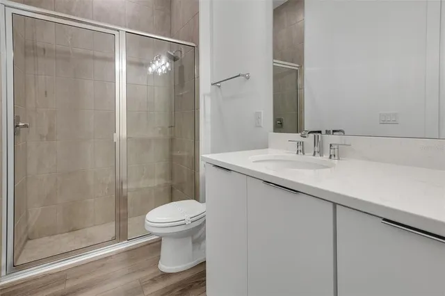 a bathroom with a granite countertop sink toilet and shower